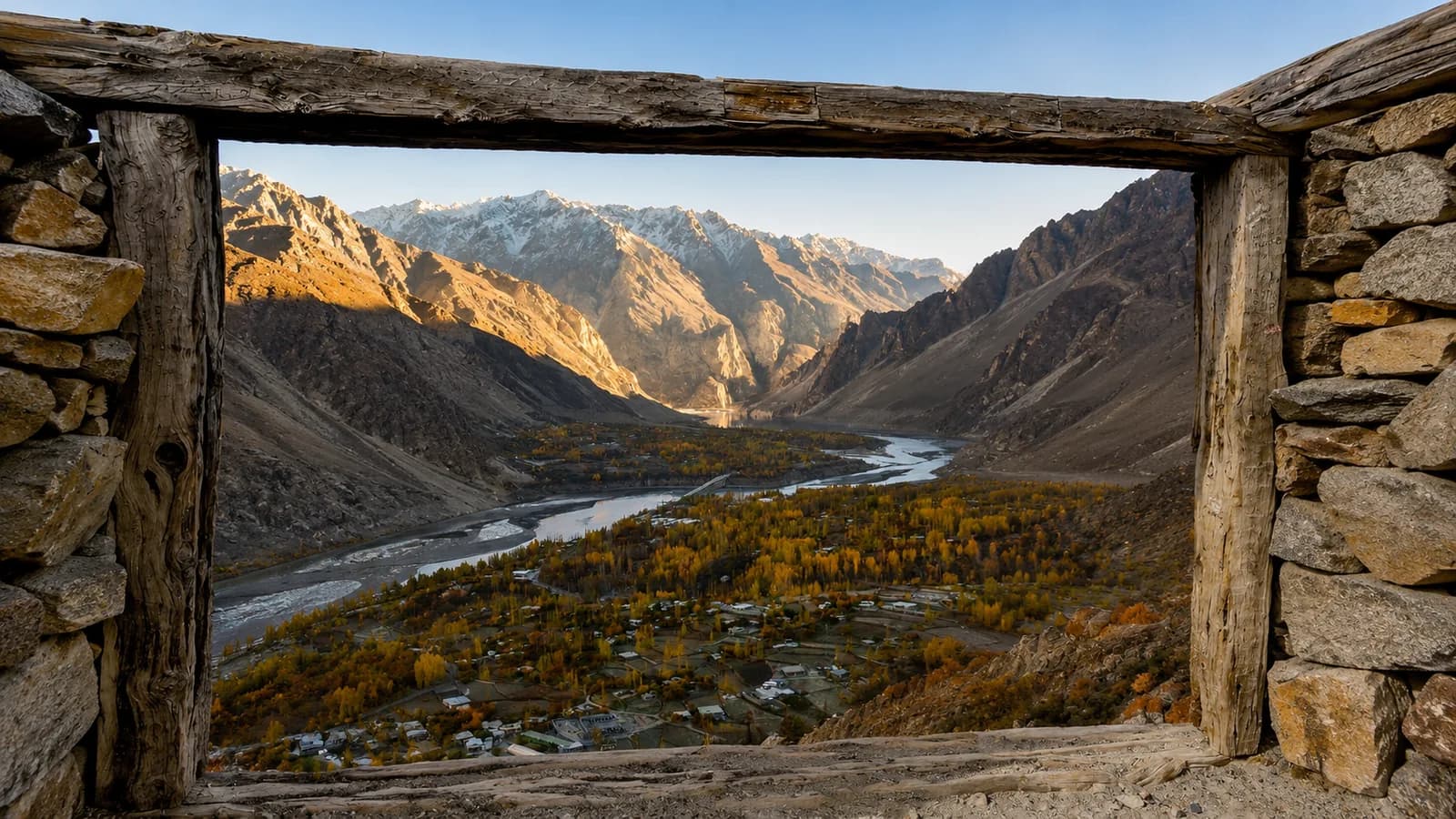 The Hunza valley and its river framed by the stone-and-timber doorway of an old building